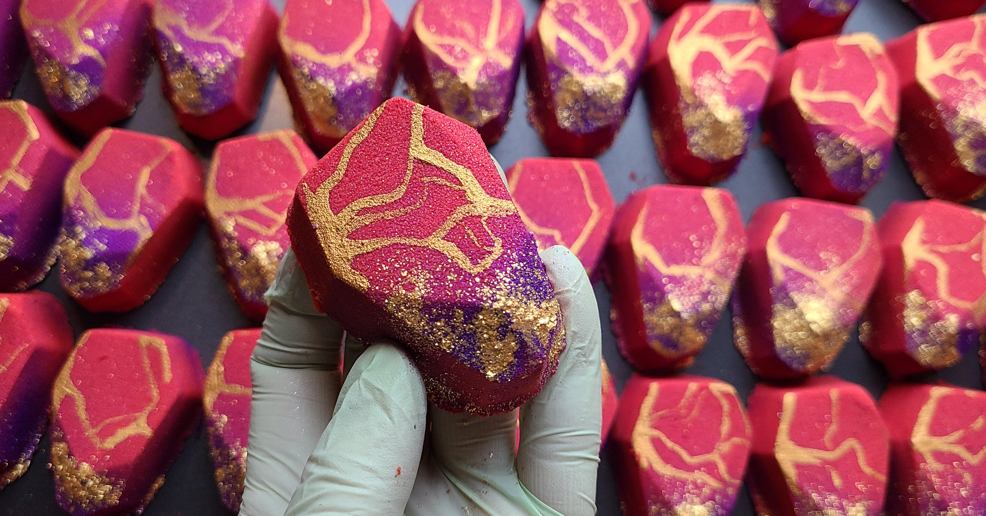 red and gold philosopher stone bath bomb with golden flecks of glitter